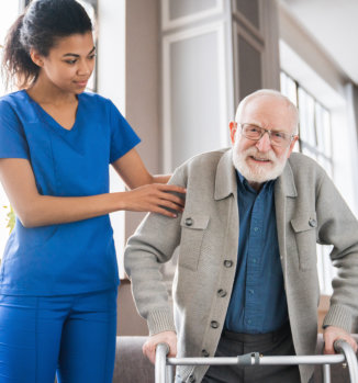 a female nurse assisting an elderly man