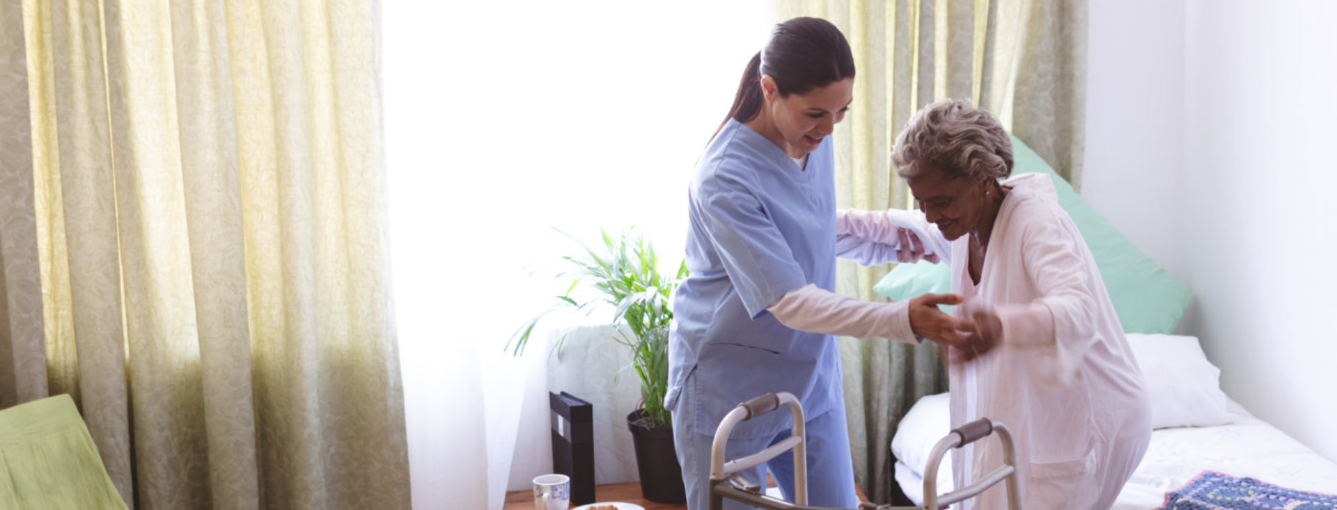 a female nurse helping an elderly woman